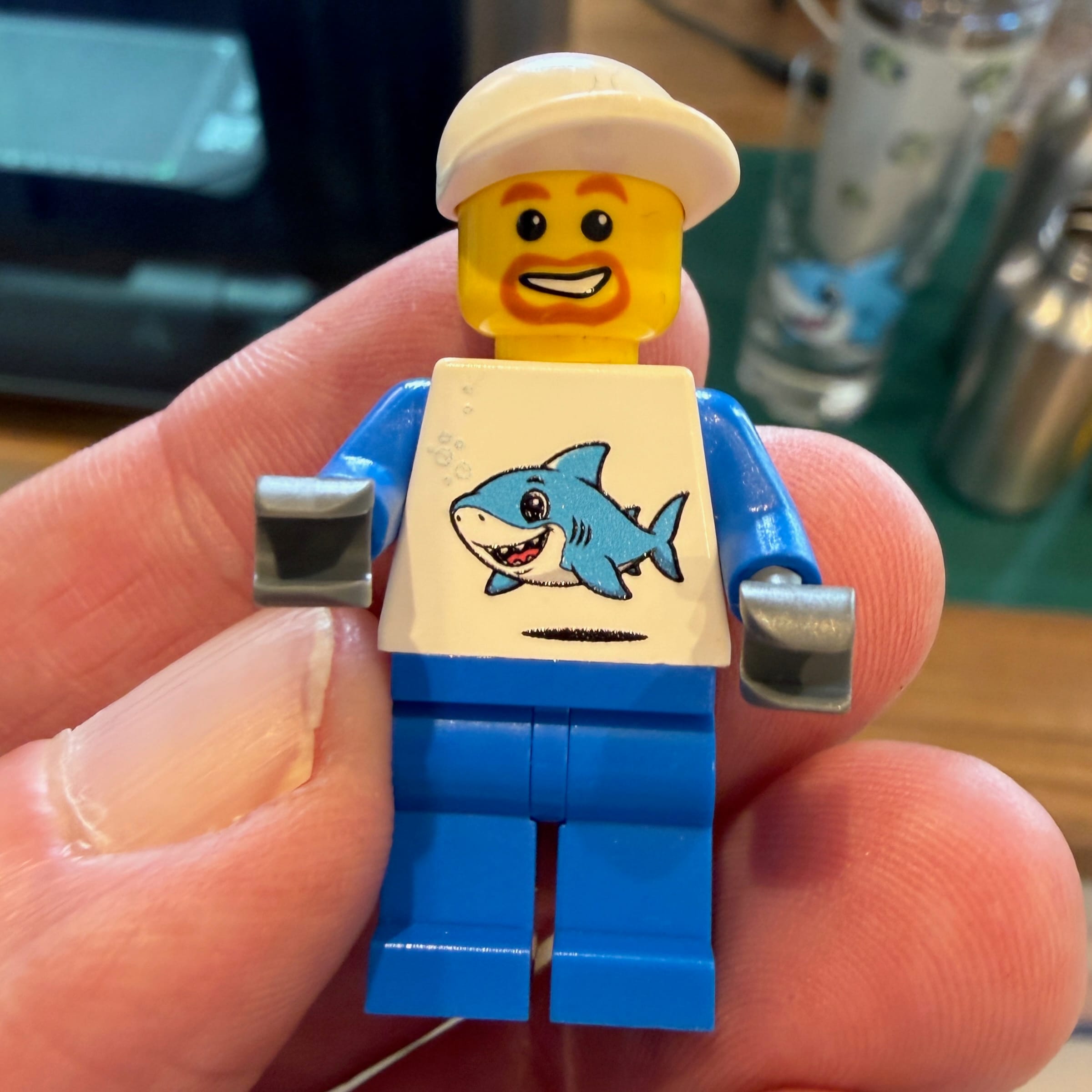 LEGO minifigure with shark t-shirt held in hand
