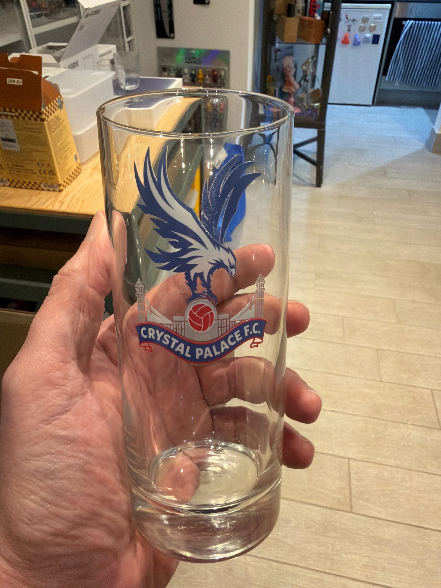 Hand holding Crystal Palace FC branded pint glass