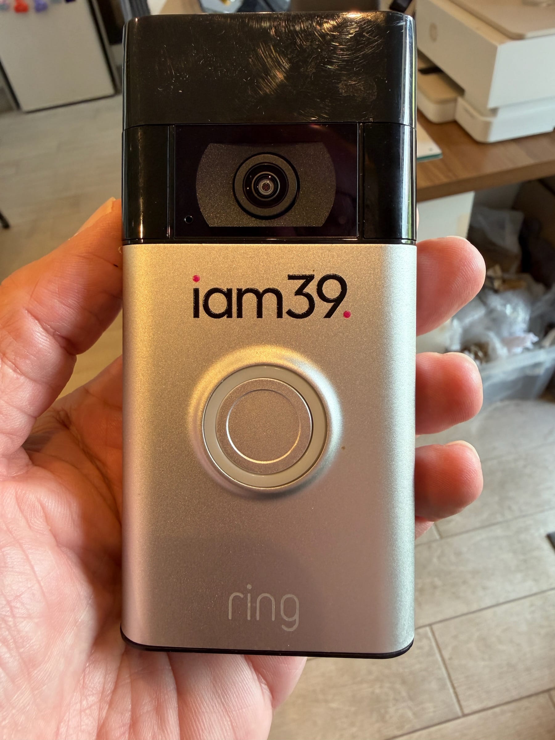 Hand holding gold Ring doorbell camera device